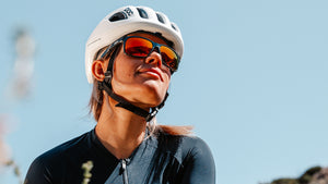 Woman in bike clothing and Oakley sunglasses looking off into the distance.