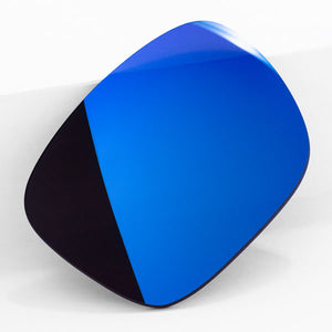 One Tidal Blue sunglass lens with mirrorshield leaning on a white wall.