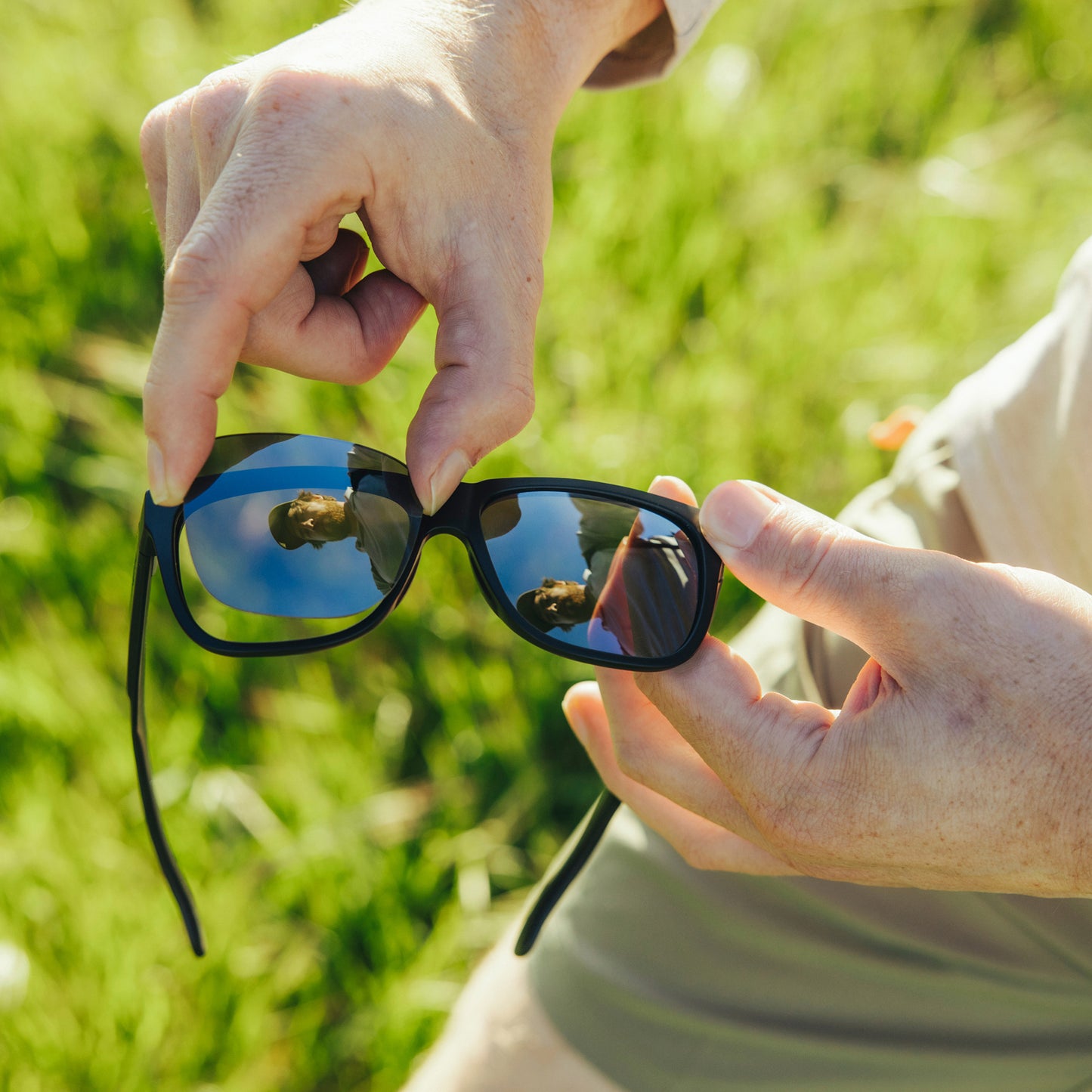 a person wearing sunglasses with black chrome lenses