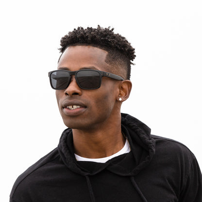 A person wearing sunglasses with Non-Polarized Adapt Gray Photochromic lenses installed in the frame