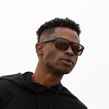 A person wearing sunglasses with Polarized Dark Brown lenses installed in the frame